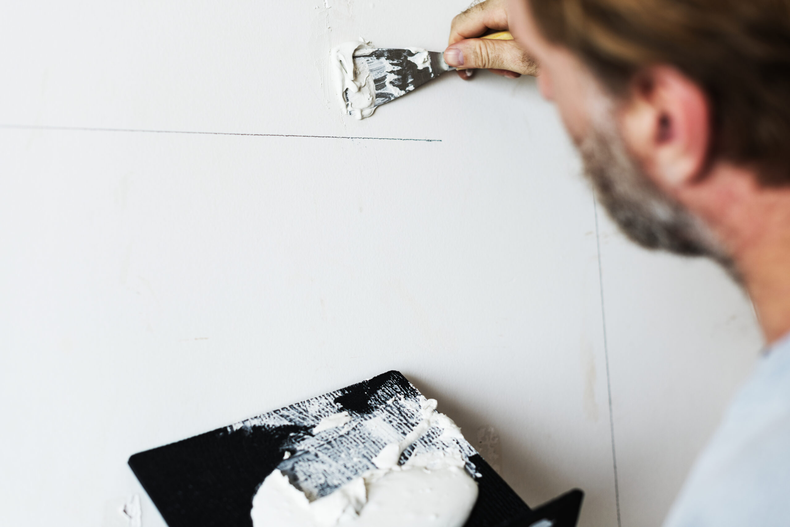 Construction worker painting the wall after crack