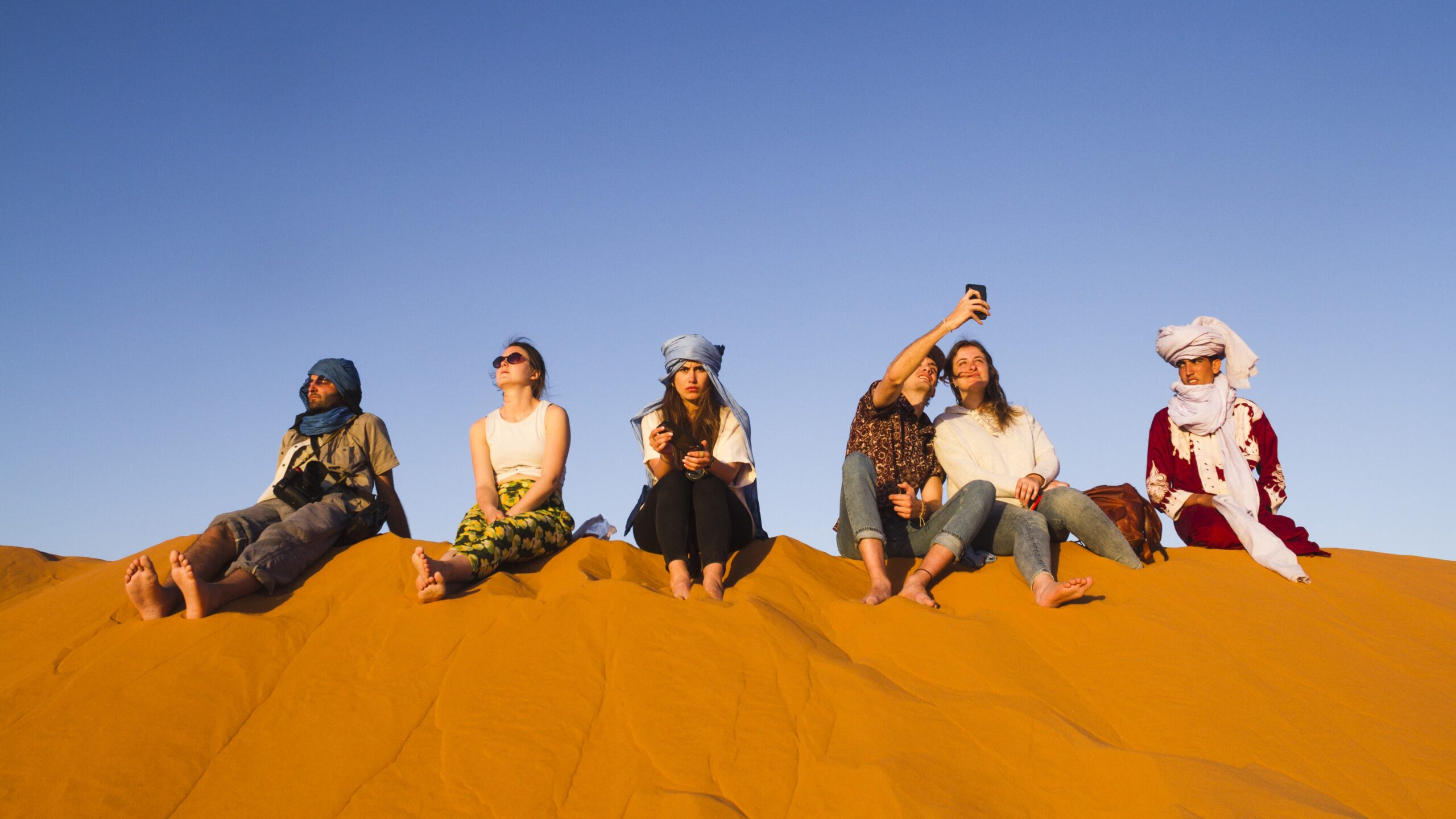 grupo-pessoas-sentadas-topo-duna-saara-marrocos