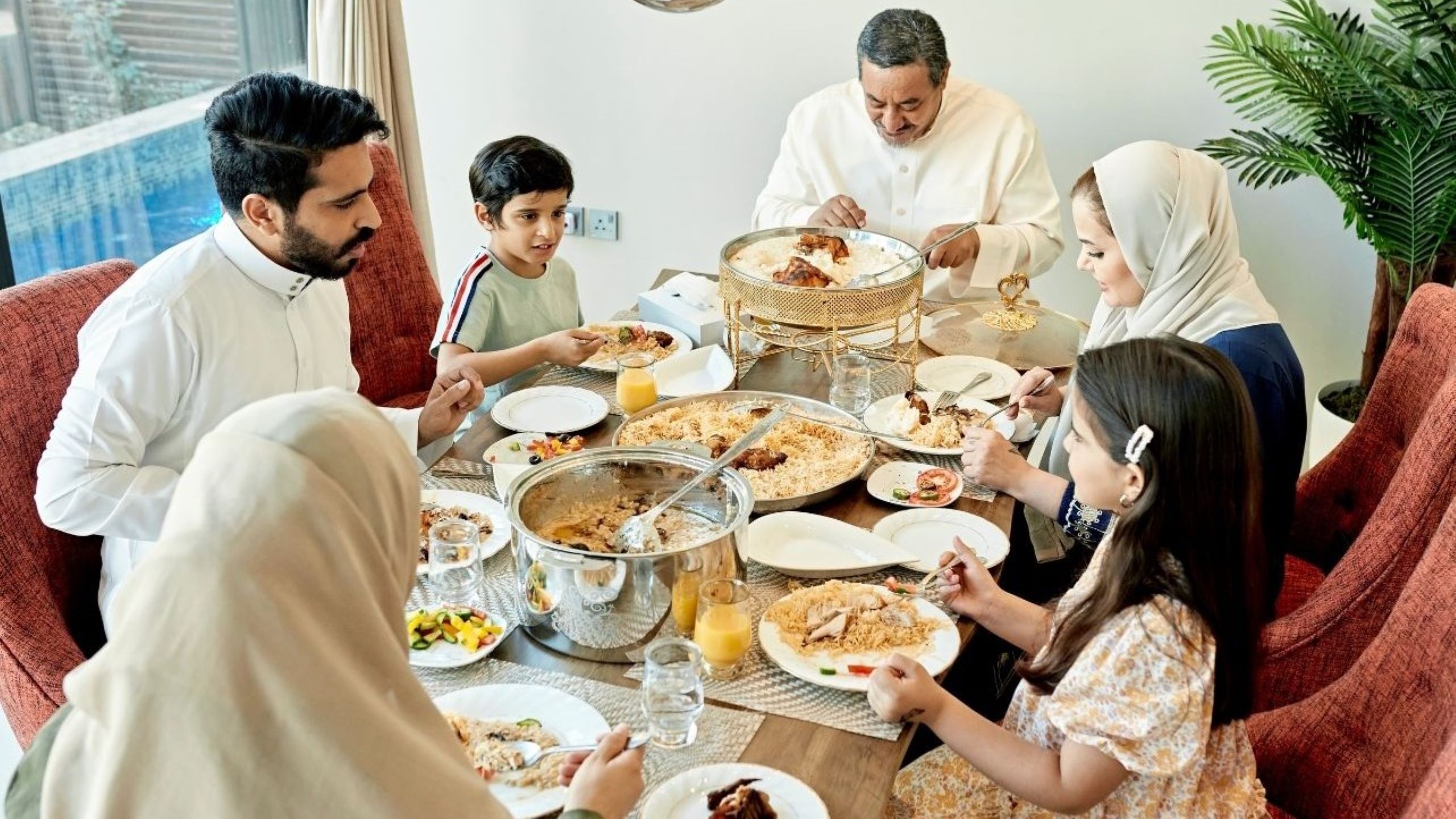 Moroccan family gathered around traditional Eid feast with couscous and tagine during holiday season celebrations, representing multicultural family traditions blending Islamic customs with Moroccan hospitality
