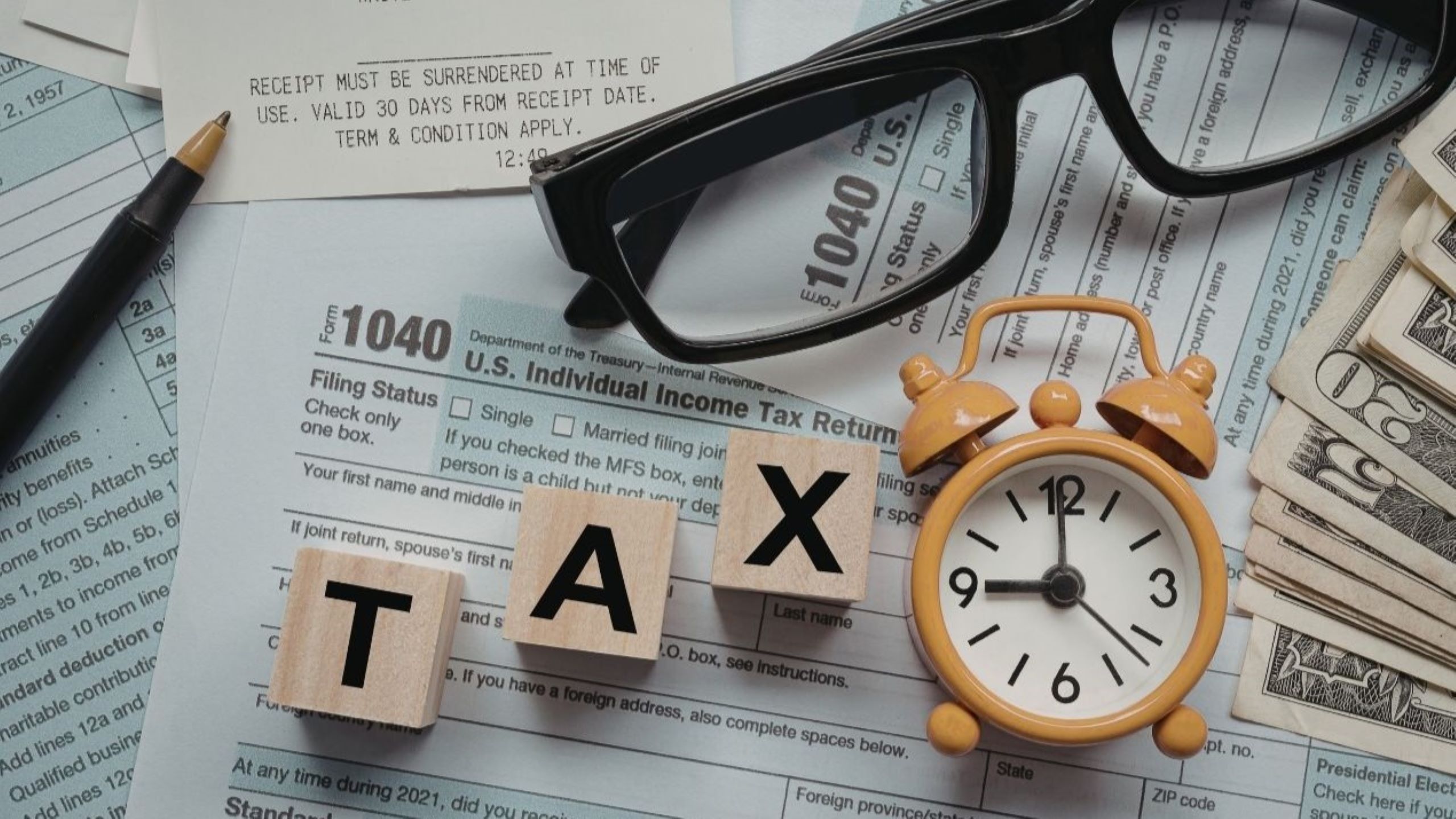 Moroccan small business owner consulting with accountant on year-end tax planning with financial documents and receipts, representing strategic deduction maximization and DGI compliance preparation