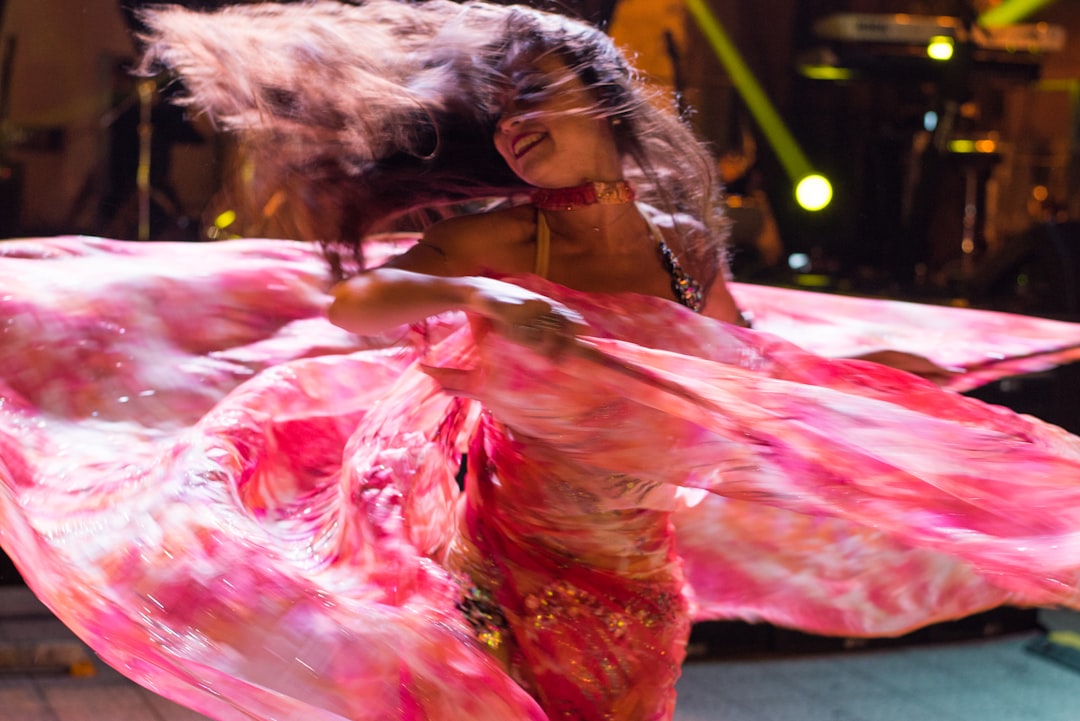 A performer in traditional costume on stage at the popular arts festival in Marrakech, surrounded by a crowd at night
