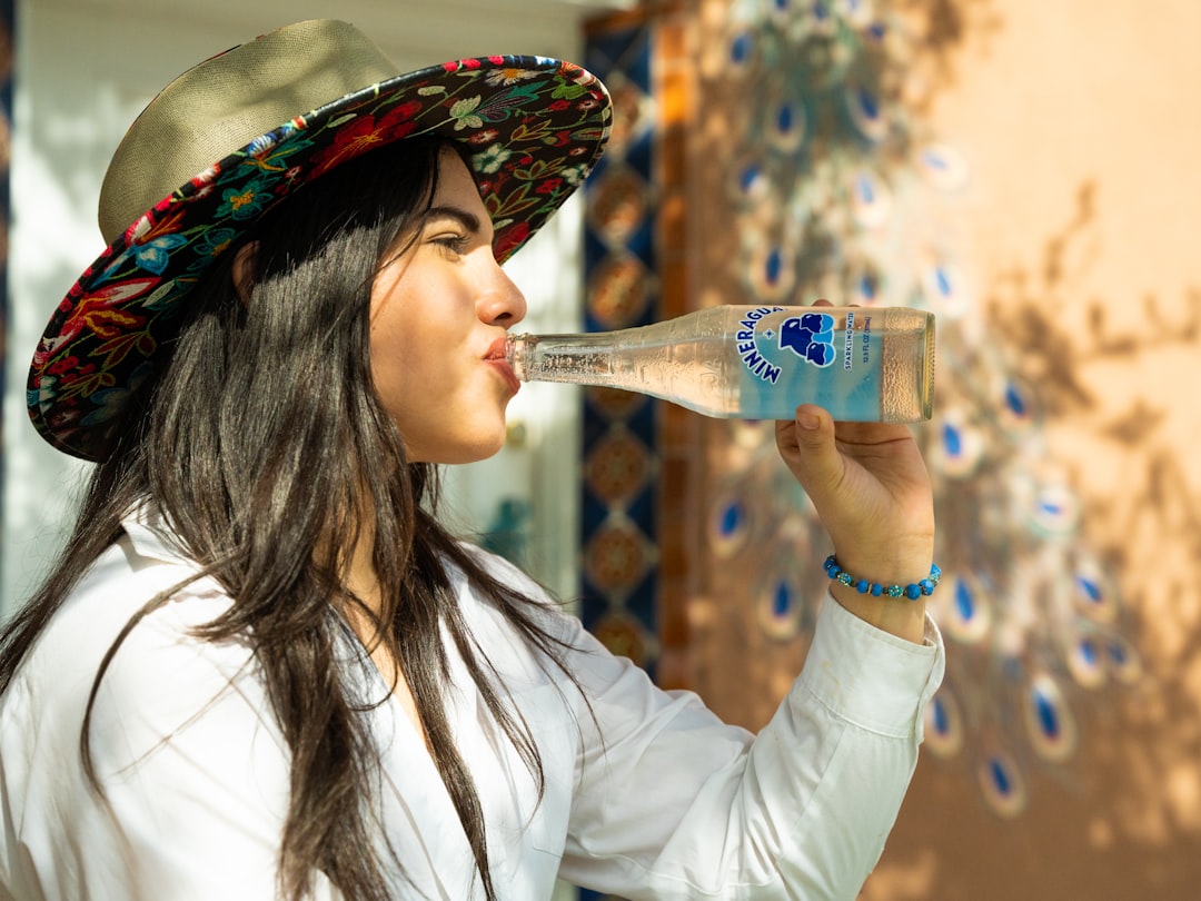 A Moroccan woman starts her morning wellness routine by drinking water at a sunlit kitchen table