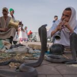 A mother and child watching street performers together, enjoying Marrakech activities at the famous Jemaa el-Fna square