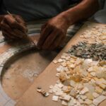 A maallem master artisan cuts hand-shaped zellige pieces in a traditional Moroccan mosaic workshop in Fez