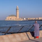 A professional woman working at a seafront café where Atlantic winds keep the air cool along Morocco's coast
