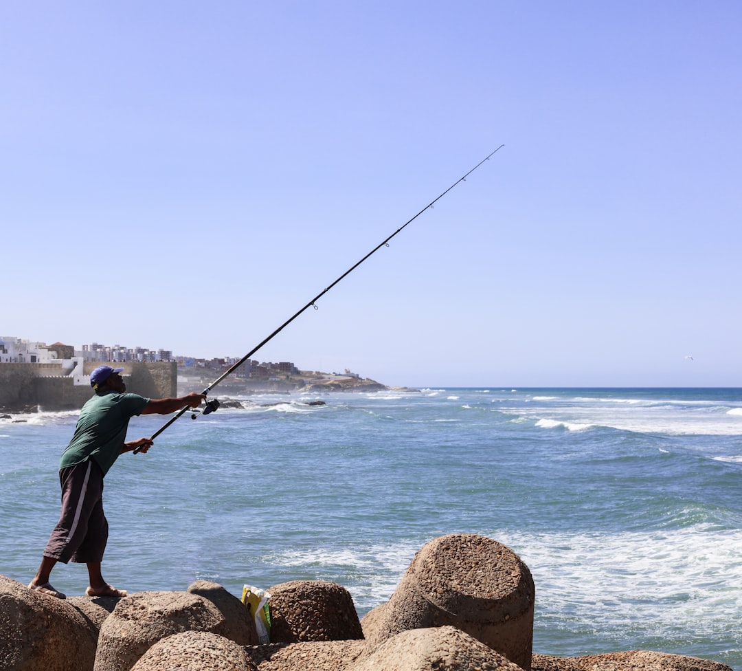 A fisherman unloads the morning fresh catch at a Moroccan coastal port, the foundation of all coastal menus in August.