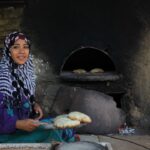 A Moroccan woman using traditional souk ingredients to prepare natural baking dough in a home kitchen