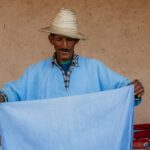 Un'artigiana marocchina che tesse tessuto all'interno di una cooperativa, mostrando il processo dietro la costruzione di un guardaroba capsula