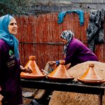 A Moroccan woman carefully preparing a traditional tagine, representing the depth of Moroccan food culture passed down.