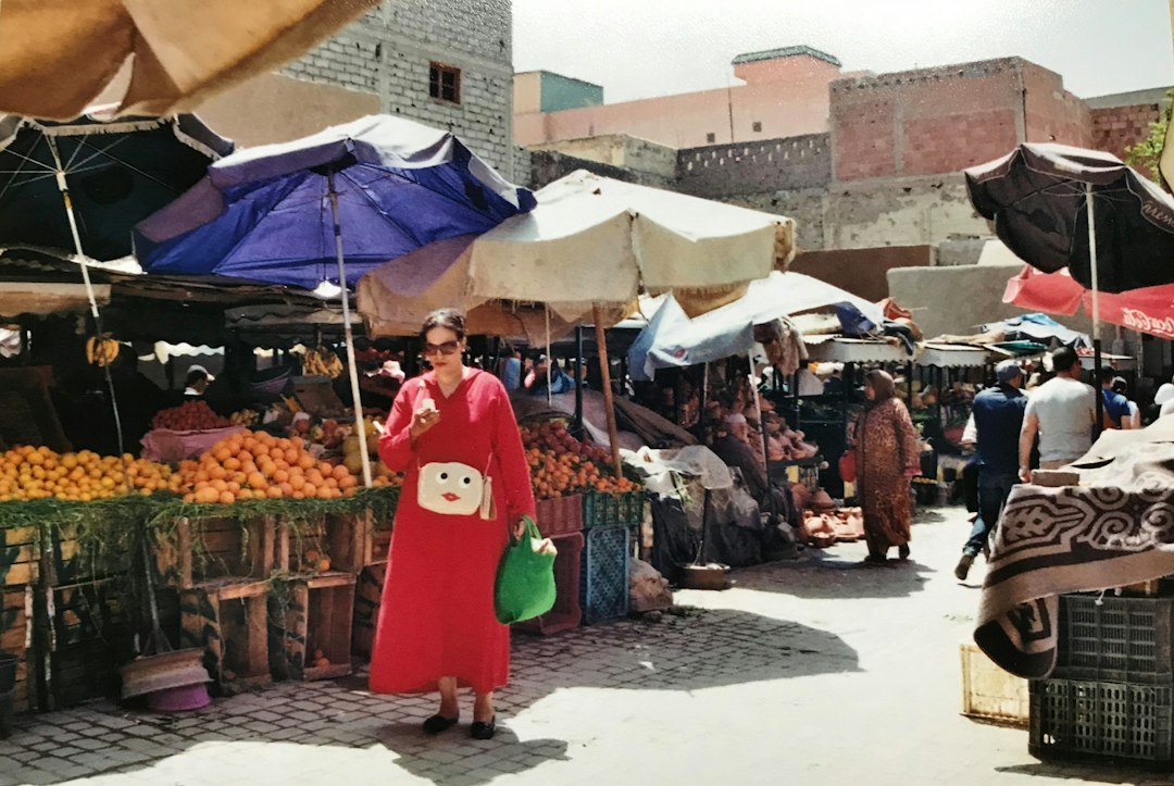 A Moroccan woman selects fresh figs at a souk stall, embracing autumn cooking with seasonal market produce