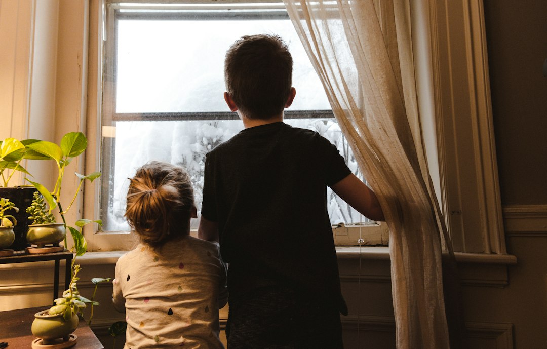 Famiglia che sigilla una corrente d'aria da una finestra per il risparmio energetico autunnale