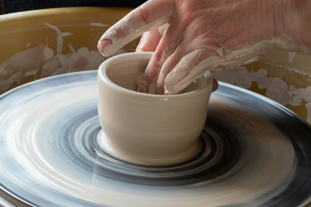 Beginner practicing a pottery hobby on a wheel in a Moroccan studio